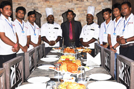 Hotel chefs and staff beside a banquet table set for dinner