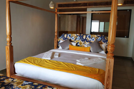 Four-poster bed dressed in gold linens